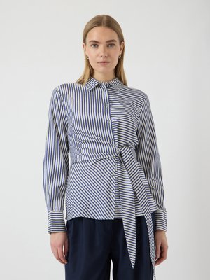 Camisa de botones a rayas con rayas verticales azules y blancas, que presenta un cinturón entallado en la cintura, mangas largas y un cuello con puntas.