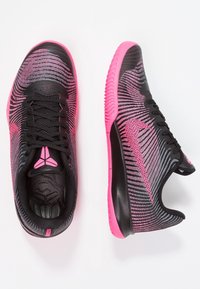 Mustat ja vaaleanpunaiset urheilukengät sisältävät tekstuuripinnan, verkkokankaisen yläosan ja kumisen pohjan, jossa on erottuva muotoilu. Koristeena swoosh-logo.