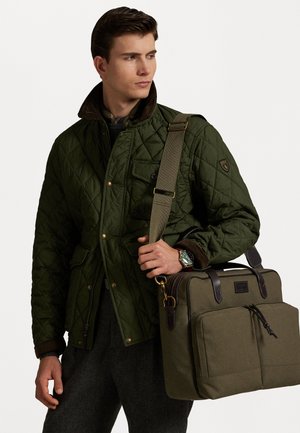 Quilted green jacket with brown collar, paired with a dark green bag featuring brown leather accents and front pockets.