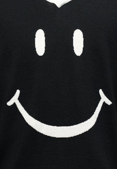 Μαύρο ύφασμα με μεγάλο λευκό σχέδιο προσωπάκι με δύο οβάλ μάτια και ευρύ καμπυλωτό χαμόγελο.