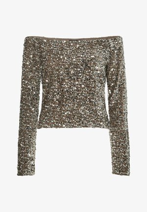 Kraštovaudų ilgomis rankovėmis palaidinė, padengta blizgančiais sidabro ir juodos spalvos sequiniais. Prigludęs dizainas su sklandžiu paviršiumi ir nematomais užsegimais.