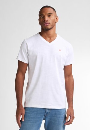 Hvid bomulds t-shirt med V-hals og korte ærmer, med et lille rødt logo på venstre bryst og en blød, glat tekstur.