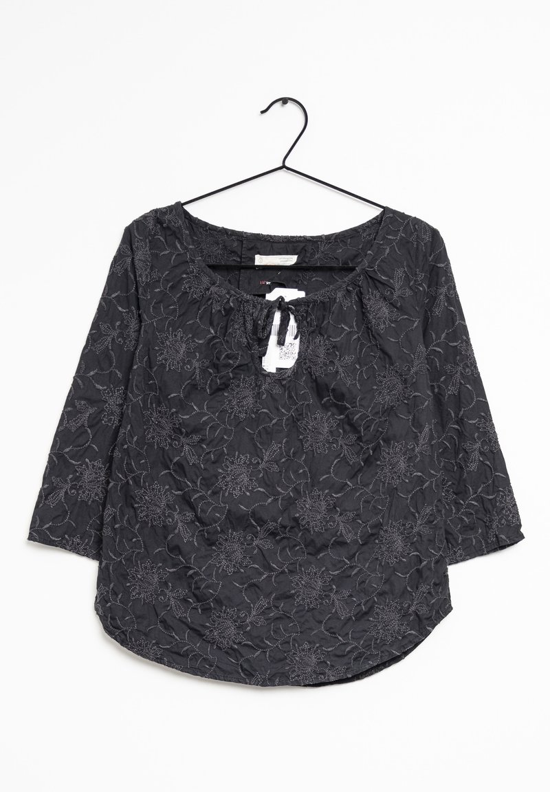Blusa nera con ricami floreali. Presenta un collo a giro, maniche a tre quarti e una vita arricciata, realizzata in tessuto testurizzato.