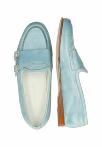 Ljusblå läderloafers med två dekorativa silverspännen, rund tå och en platt träsoffa, med slät textur och minimal design.