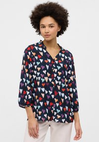 Dark blue blouse with a heart pattern in various colors. Features a v-neckline, three-quarter sleeves, and button front closure.
