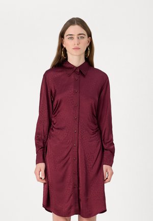 Maroon, napakattava mekko, joka on valmistettu sileästä, kevyestä kankaasta. Siinä on kauluspääntie, rypytetyt sivut ja pitkät hihat napillisilla hihansuilla.