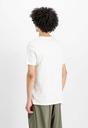 Camiseta de algodón blanca con escote redondo y mangas cortas. La vista trasera muestra una textura suave y un dobladillo recto.