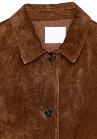 Brun ruskindjakke med spids krave, frontknaplukning og subtil tekstur. Mærketikette synlig inden i kraven.