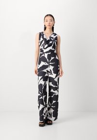 Mono floral en blanco y negro con escote drapeado, piernas anchas y cintura ceñida. Fabricado con un tejido suave y ligero.