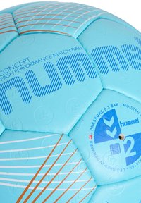 Ljusblå handboll med en texturerad yta. Har blåa och orange grafiska ränder, präglade logotyper och en ventil för uppblåsning.