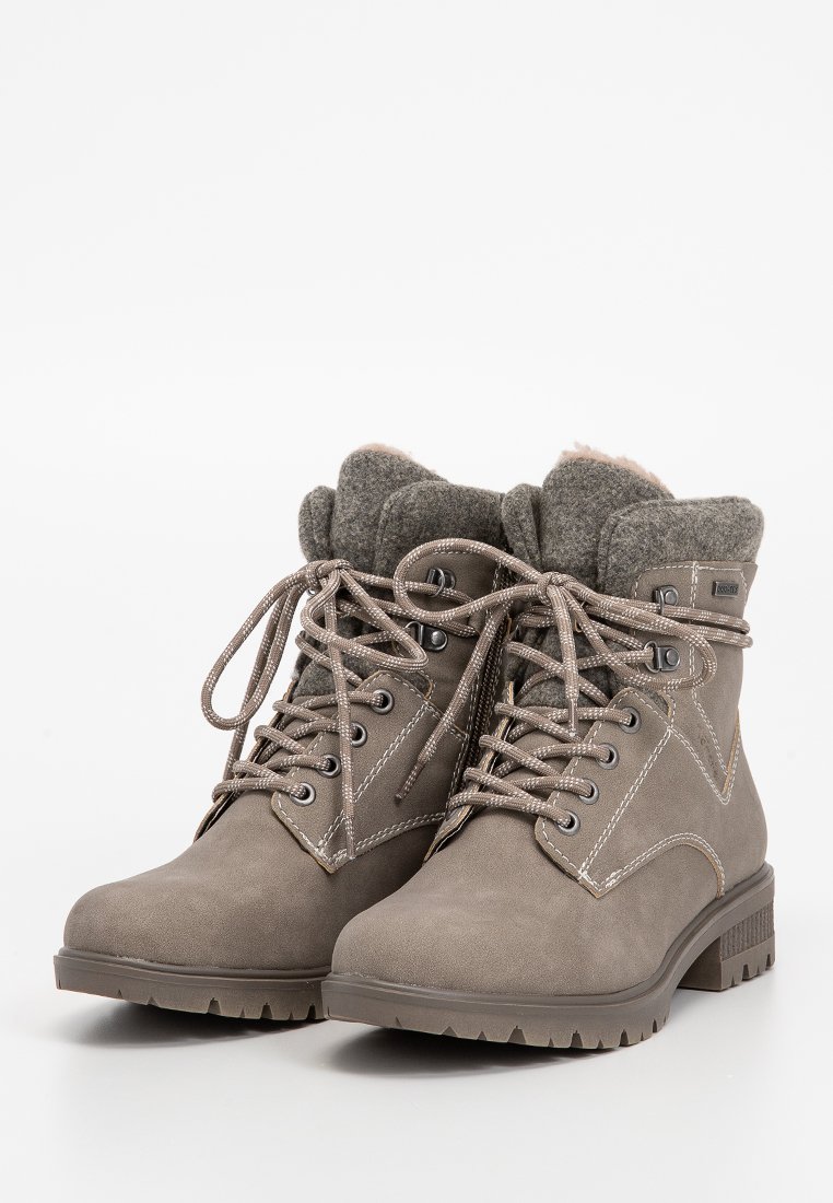 Een paar grijze winterlaarzen met veters, met getextureerde rubberen zolen en zachte, gevoerde wollen kraag, naast elkaar gepositioneerd op een witte achtergrond.