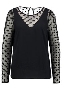 Černá blůza se strukturovaným tělem a průhlednými dlouhými rukávy s puntíkovaným vzorem. Výstřih do V s malým zapínáním na knoflík vzadu.
