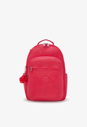 Röd Kipling ryggsäck med framficka med dragkedja, två dragkedjehandtag, sidofickor, ett handtag på toppen och en liten röd apa nyckelring fästad.