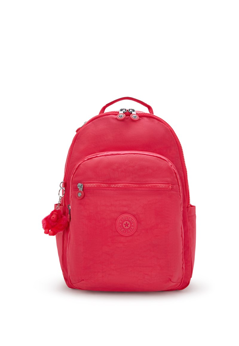 Röd Kipling ryggsäck med framficka med dragkedja, två dragkedjehandtag, sidofickor, ett handtag på toppen och en liten röd apa nyckelring fästad.