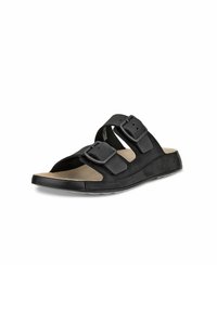 Mules noires avec deux sangles réglables à boucle, une semelle intérieure ergonomique et une semelle en caoutchouc texturée. Matériau supérieur lisse.