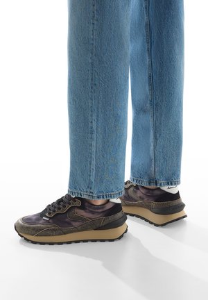 Sneakers con un mix di materiali neri, marroni e viola, caratterizzati da una finitura testurizzata, una suola spessa e lacci tradizionali.