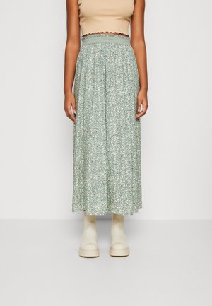 Midi-rok in lichtblauw met bloemenpatroon en een aangesloten tailleband, gecombineerd met crèmekleurige plateau enkellaarsjes. Geweven stof en een vloeiend ontwerp.