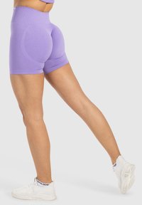 Lila högmidjade träningsshorts med en slät textur och figurnära design, med en elastisk midja och längd till mitten av låret.