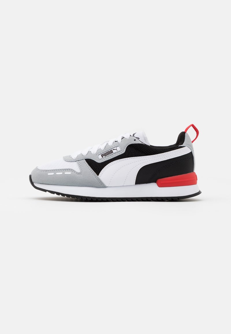 Puma sneakers featuring a mesh and suede upper in white, grey, and black, with a red accent on the heel and a rubber sole.