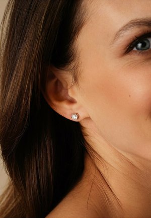 Round cubic zirconia stud earrings set in silver-tone metal, featuring a polished finish and a secure backing.