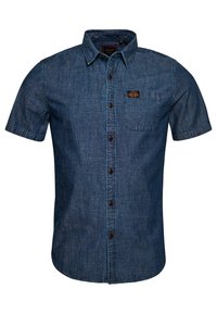 Koszula jeansowa z krótkim rękawem w ciemnym odcieniu niebieskiego, z kołnierzykiem zapinanym na guziki, przednią kieszenią oraz kontrastującymi brązowymi guzikami. Miękka, teksturowana tkanina.