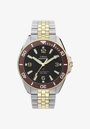 Ceas de mână Timex Deepwater cu cadran negru, brățară metalică aurie și argintie, indicatoare luminoase și bezel maro rotativ marcat pentru scufundări.