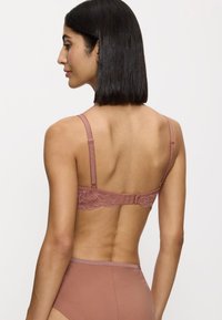 Bra con schienale in pizzo color rosa polveroso con spalline regolabili, dotato di chiusura a gancio. Fascia liscia. Materiale morbido e elastico con pizzo decorativo.