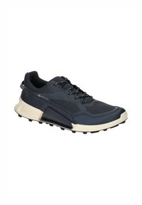 Navy blue athletic shoe with a textured upper, GORE-TEX label, white sole, and rubber traction outsole. Features lacing and padded collar.