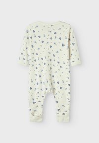 Blommönstrad baby jumpsuit i mjuk bomull. Har en ljuskrämfärgad bakgrund, långa ärmar och elastiska mudd vid anklarna.