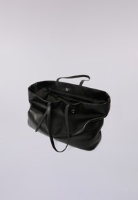 Bolso tote de cuero negro con una forma suave y estructurada, que cuenta con dos asas para el hombro y un bolsillo interior con cremallera. Textura suave con un acabado mate.