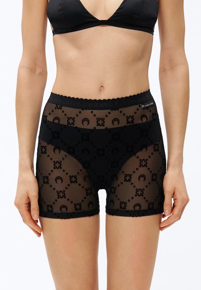 Schwarze, durchsichtige Shorts mit floralem Muster, gewelltem Bund und glatter Textur. Verziert mit kleinen runden Applikationen.