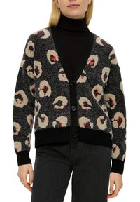 Zwart oversized cardigan met een luipaardpatroon in beige en rood. V-hals, knoopsluiting en zwarte geribde manchetten en zoom. Zachte textuur.