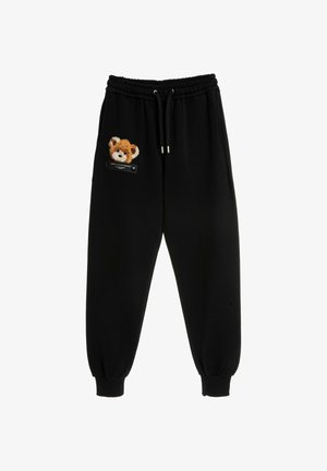 Joggers de forro polar negros con un diseño de oso de peluche en un bolsillo, cinturilla elástica y tobillos ajustados para un ajuste cómodo.