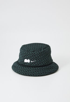 Bucket-hatt av mörkgrönmönstrad tyg, med texturerad vävd design och broderade vita logobroderier på framsidan.