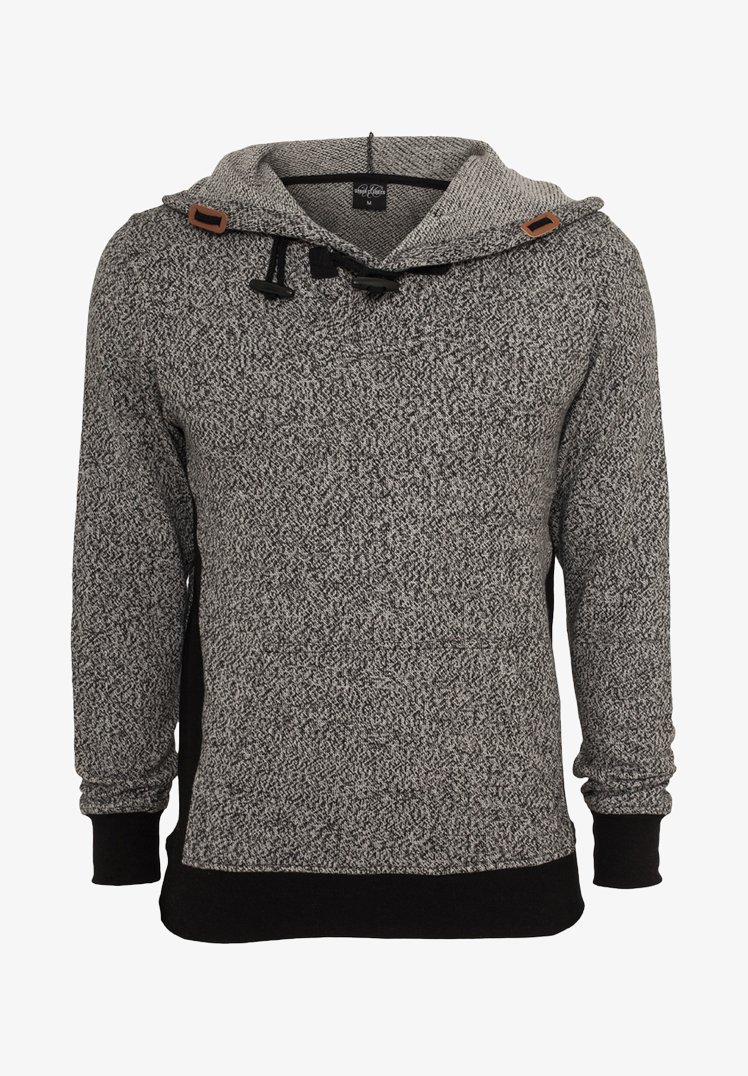 Szürke kötött kapucnis pulóver, texturált mintával, húzózsinórral ellátott kapucnival és barna bőr részletekkel. Fekete mandzsetta és szegő rész. Hosszú ujjú.