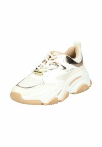 Sneaker bianco con accenti beige e metallici, suola spessa, materiali in rete e pelle, punta tonda e motivi di battistrada intricati.