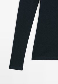 Mörkblå långärmad topp i ribbad tyg. Har slim fit, rund halsringning och muddar med jämn sömnad. Mjuk textur.