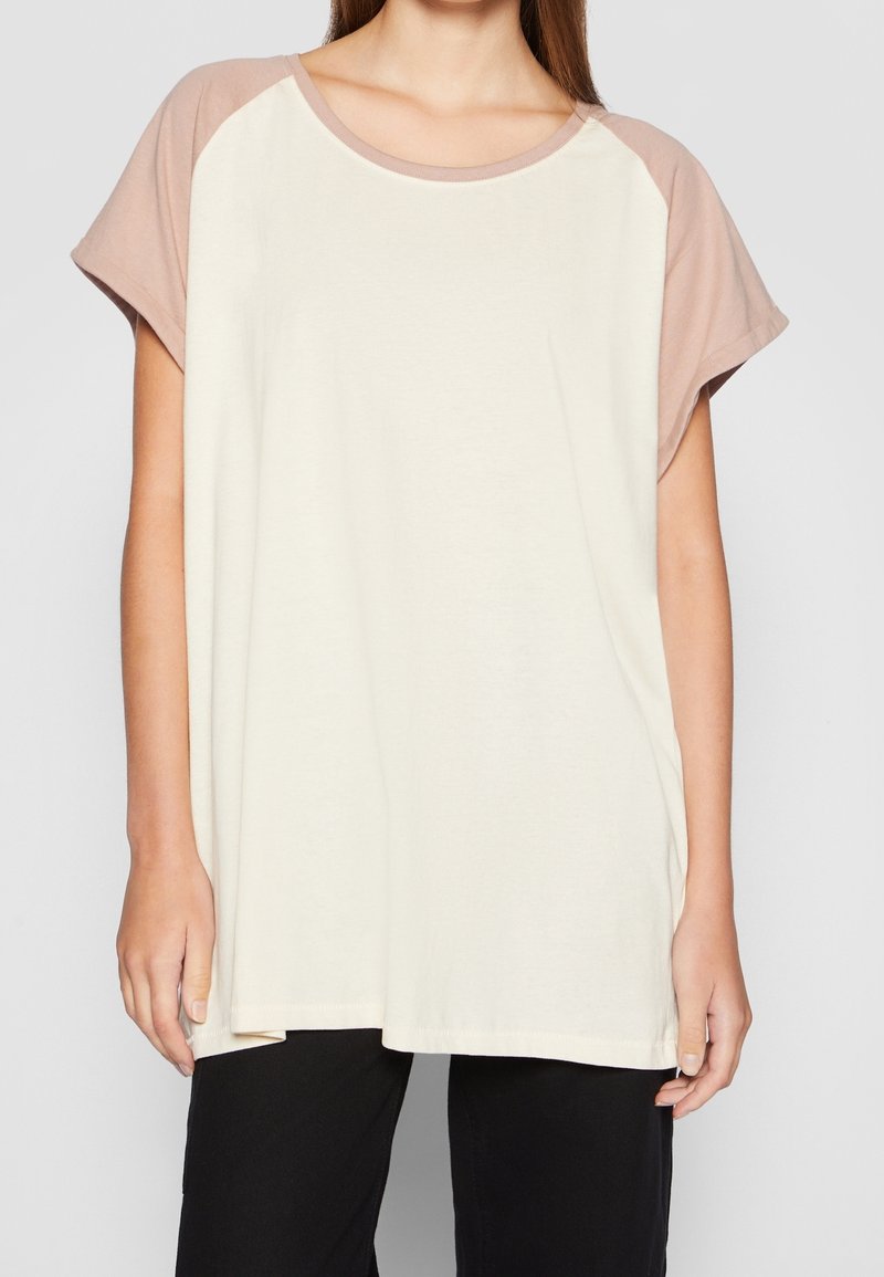 Lätt, krämfärgad t-shirt med korta, insydda ärmar i en mjuk taupe färg. Har en rundad halsringning och en avslappnad passform.