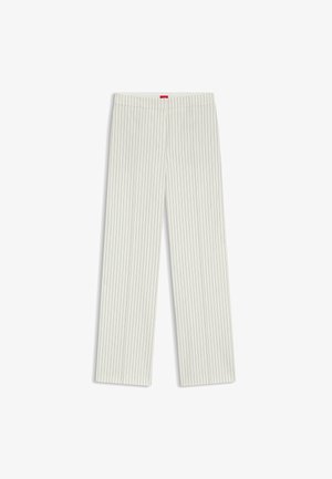 Pantaloni ampi di colore chiaro con righe verticali. Presentano una texture liscia e una vita elasticizzata; includono un piccolo etichetta rossa sul retro.