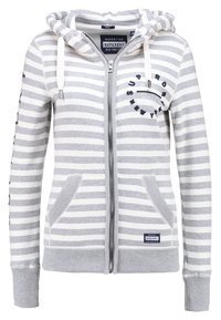 Felpa con cappuccio a righe grigie e bianche, con zip, coulisse, tasche frontali e logo "Superdry New York" sul petto e sull'orlo.