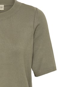 Oliv zaļas krāsas īsroku trikotāžas topiņš ar apaļu kakla izgriezumu, kas izceļas ar rūdītu ribotu rakstu un mīkstu apdari.