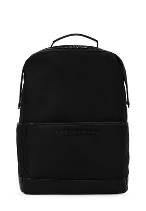 Sac à dos noir en matériau lisse. Dispose d'une fermeture éclair, d'une poignée supérieure et d'un logo de marque embossé à l'avant. Design minimaliste.