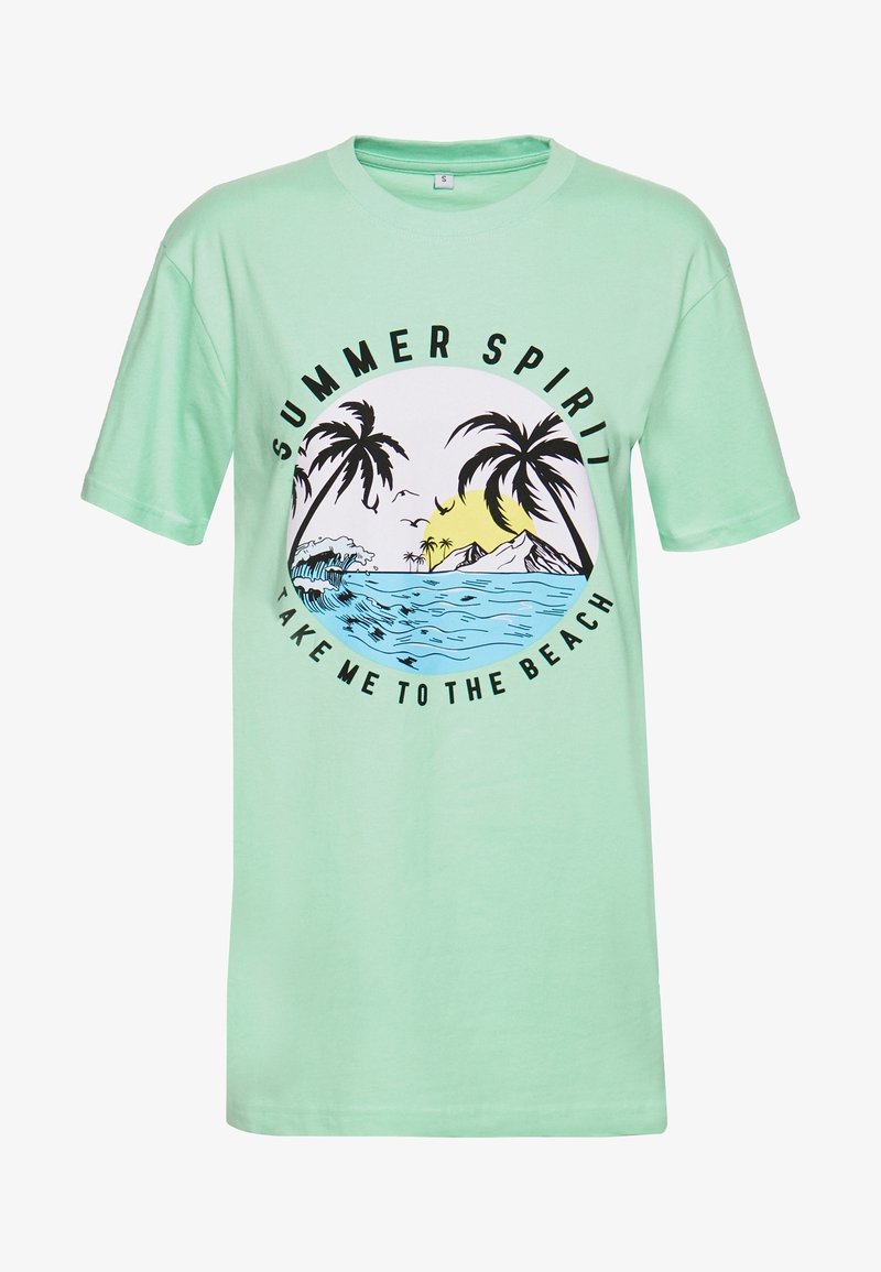 T-shirt en coton vert menthe avec un graphique circulaire représentant des palmiers, des vagues et un soleil. Le texte indique "ESPRIT D'ÉTÉ" et "EMMÈNE-MOI À LA PLAGE."