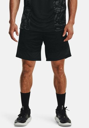 Schwarze Sportshorts aus leichtem Material mit strukturiertem Design, atmungsaktivem Stoff und lockerem Sitz, kombiniert mit schwarzen Socken und Turnschuhen.