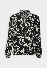 Svart blus med v-ringad hals, långa ärmar och en lös passform som har ett abstrakt vitt mönster över tyget. Mjukt, lätt material.