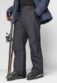 Mustad muste isolatsiooniga suusapüksid kitseneva lõikega, millel on tugevdatud õmblused, küljetaskud ja tekstuuriga kangas vastupidavuse tagamiseks.