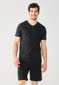 Men's short-sleeve V-neck t-shirt in black with a textured, striped pattern; paired with black shorts. Soft fabric, casual fit.