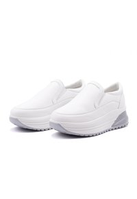 Scarpe bianche senza lacci con tomaia in pelle liscia, suola più spessa ed elevata, e sottili accenti grigi sul tallone e sulla suola. Motivo testurizzato sulla suola.