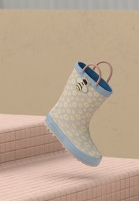 Blue rubber rain boot, adorned with a white daisy pattern and a bee accent, pink handle, textured sole, and smooth interior.