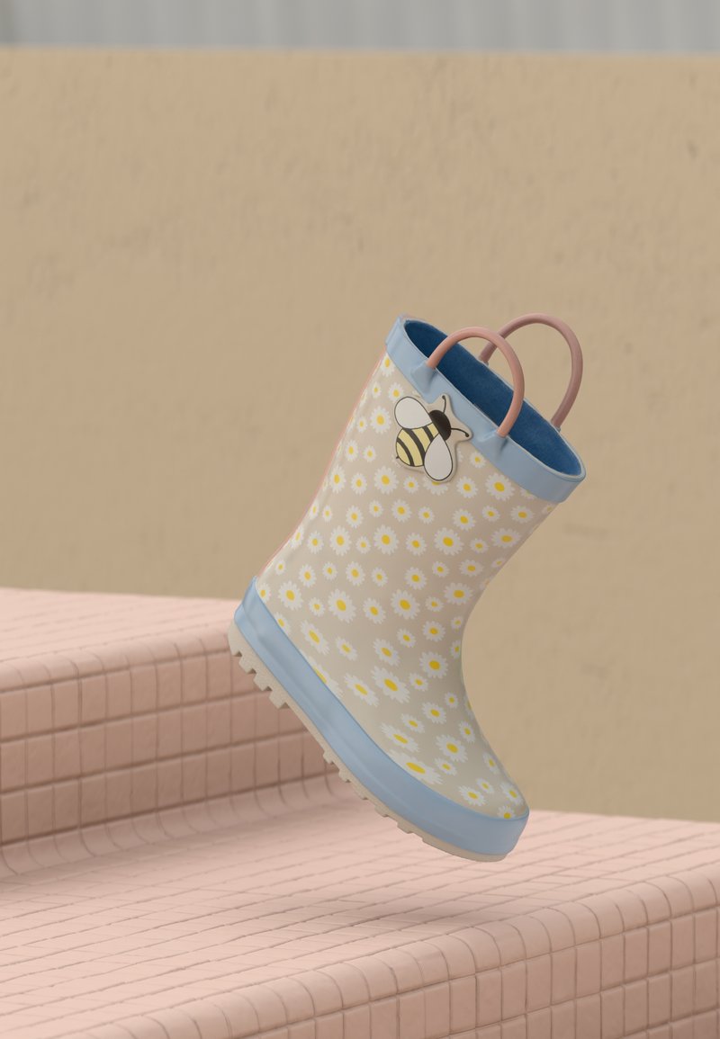Blue rubber rain boot, adorned with a white daisy pattern and a bee accent, pink handle, textured sole, and smooth interior.